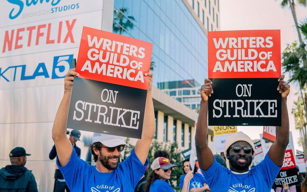 Foto de roteiristas segurando placas em favor da greve em frente a estúdio da Netflix
