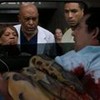Imagem dos médicos de Greys Anatomy olhando para um homem que está enrolado em uma cobra