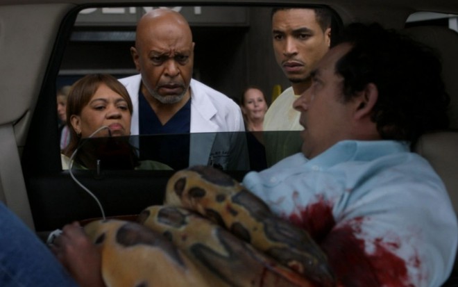 Imagem dos médicos de Greys Anatomy olhando para um homem que está enrolado em uma cobra