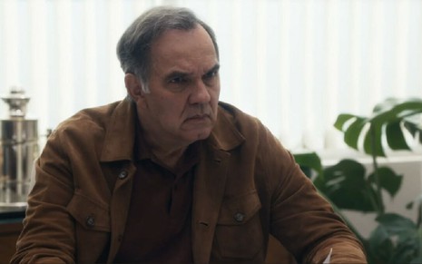 Em cena de Travessia, Humberto Martins está com a expressão de raiva; ele usa jaqueta marrom por cima de uma blusa preta