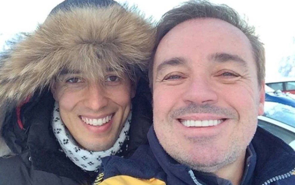 Thiago Salvático e Gugu Liberato em selfie, ambos sorrindo, com roupas de frio