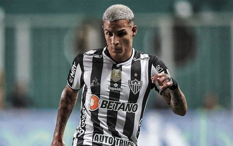 Guilherme Arana, do Atlético-MG, em campo pelo clube usando uniforme listrado preto e branco