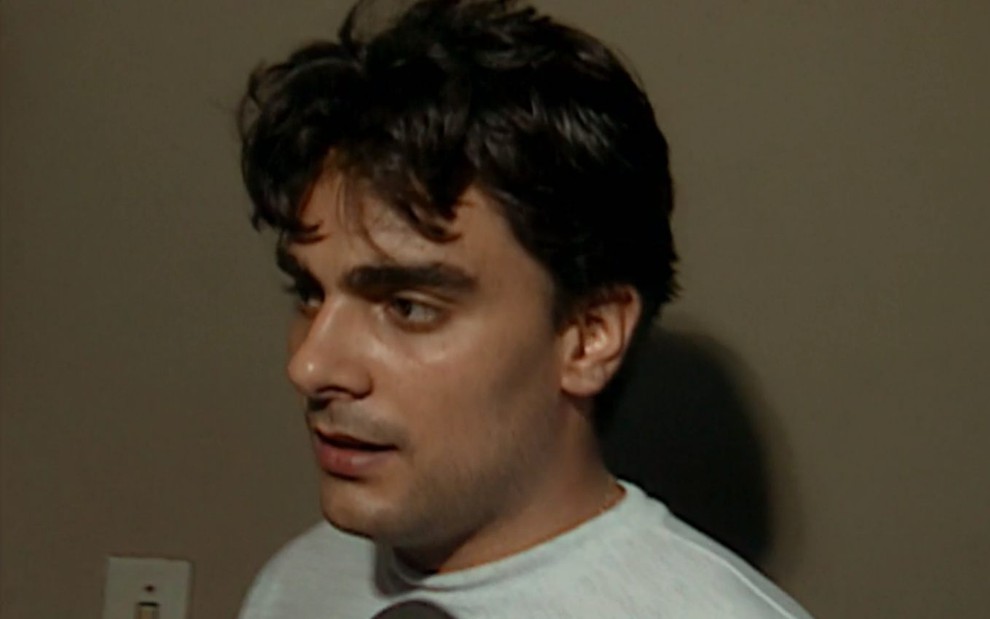 O ator Guilherme de Pádua no passado em imagem da série Pacto Brutal; ele está de lado enquanto conversa olhando para frente