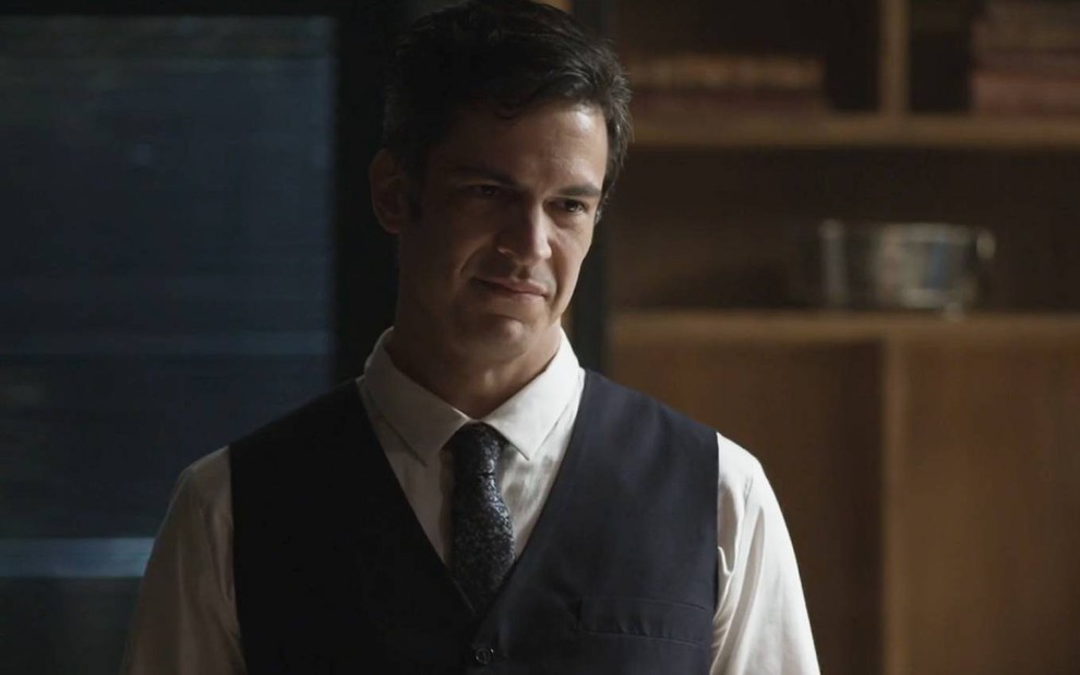 O ator Mateus Solano de camisa, colete e gravata, com expressão séria em cena de Quanto Mais Vida, Melhor