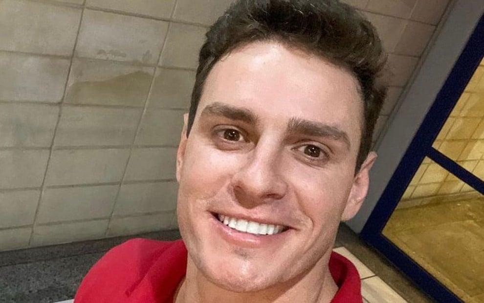 Gustavo Benedeti sorri e está de camiseta vermelha em selfie