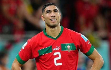 Achraf Hakimi, de Marrocos, em campo pela seleção com uniforme vermelho com faixa verde