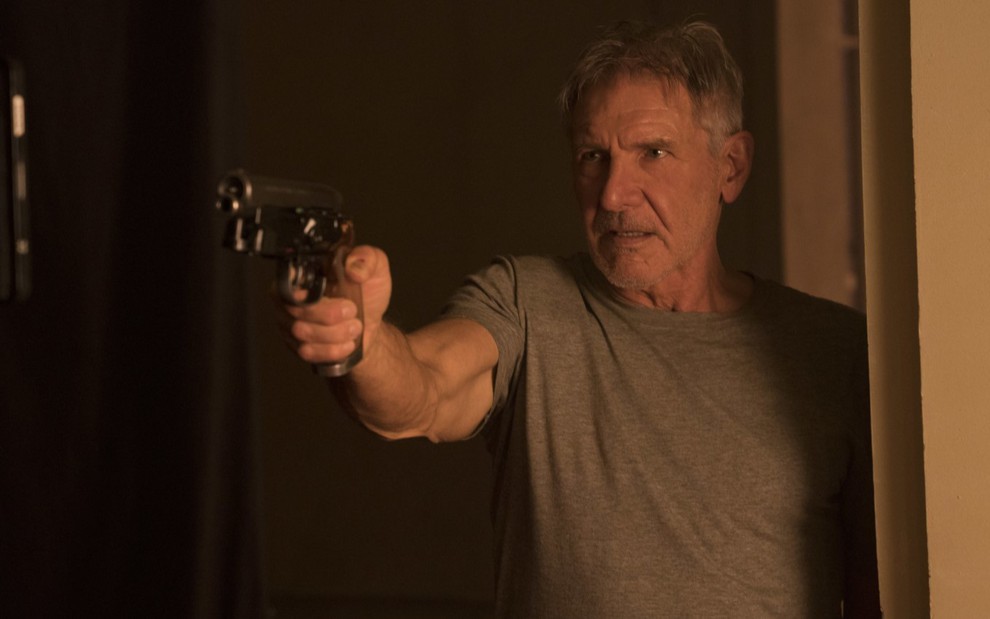Harrison Ford com arma na mão em cena de Blade Runner 2049