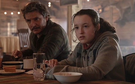 Imagem com Joel (Pedro Pascal) e Ellie (Bella Ramsey) se alimentando em The Last of Us