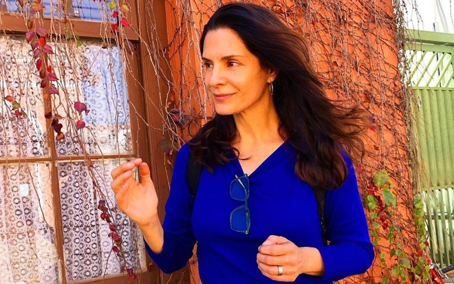 Helena Ranaldi olha para o lado enquanto o vento balança seus cabelos