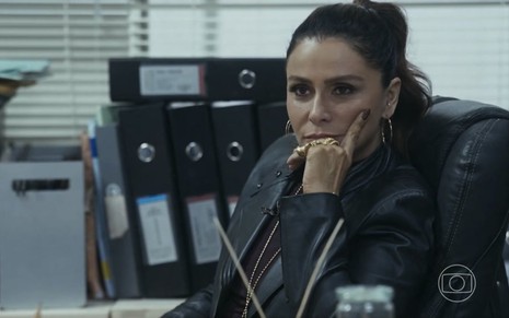em cena de Travessia, Giovanna Antonelli está de cabelo preso, pensativa, com o rosto apoiado na mão