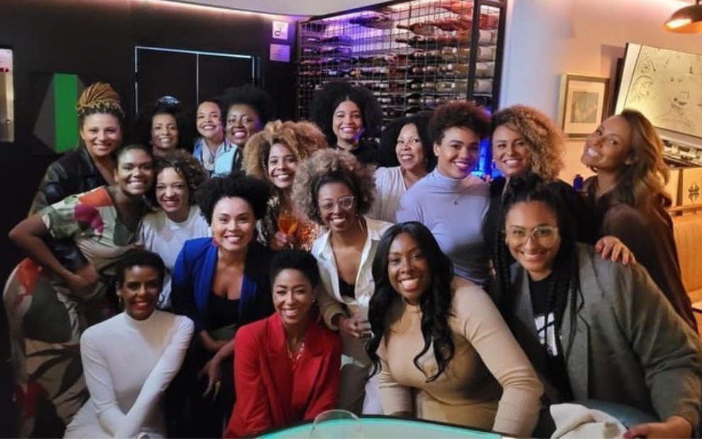 Jornalistas negras unidas em foto tirada em área interna de restaurante
