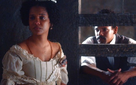 Zayla (Heslaine Vieira) conversa com Samuel (Michel Gomes), que está na prisão em cena da novela Nos Tempos do Imperador