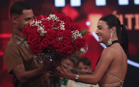 Imagem de Gabriel Roza (à esq.) pedindo Bia Miranda em casamento no palco do Hora do Faro