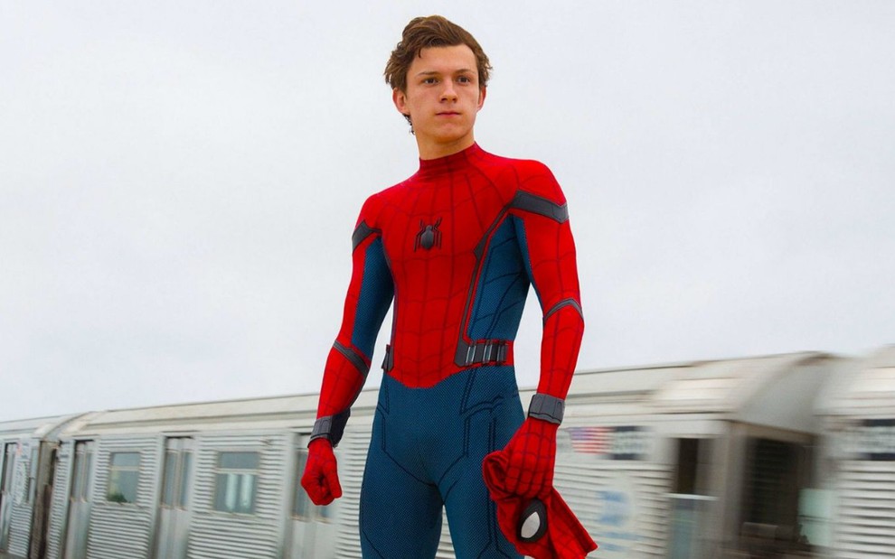Vestido como Homem-Aranha, mas sem a máscara, Tom Holland olha para o horizonte com pose heroica