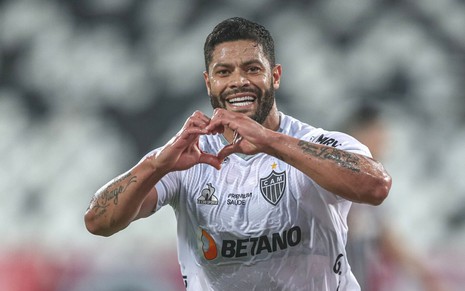 O atacante Hulk faz um coração com aos mãos enquanto comemora gol do Atlético-MG; ele está com uniforme branco