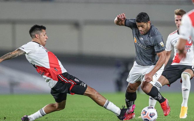 Hulk, jogador do Atlético divide a bola com jogador do River Plate