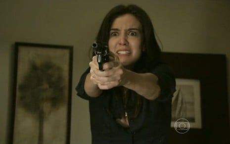 Cora (Marjorie Estiano) está com revólver apontado para Reginaldo (Flávio Galvão), que não aparece na foto, em cena de Império
