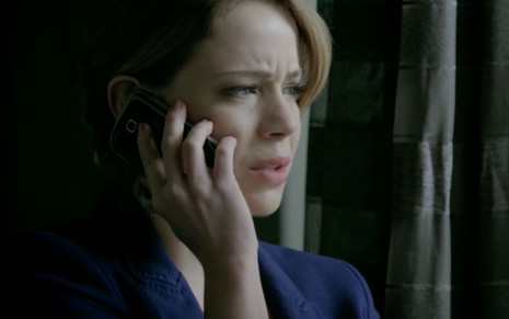A atriz Leandra Leal com celular no ouvido e expressão de apreensão em cena como Cristina em Império