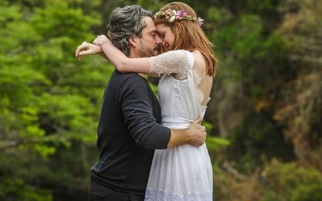 Os atores Alexandre Nero e Marina Ruy Barbosa abraçados, bem juntos, vestidos de noivos em cena de Império
