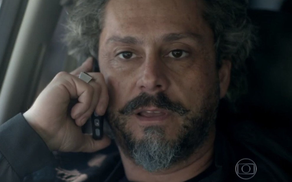 Alexandre Nero em cena de Império: personagem está caracterizado como José Alfredo, com telefone na orelha e olhar de atenção
