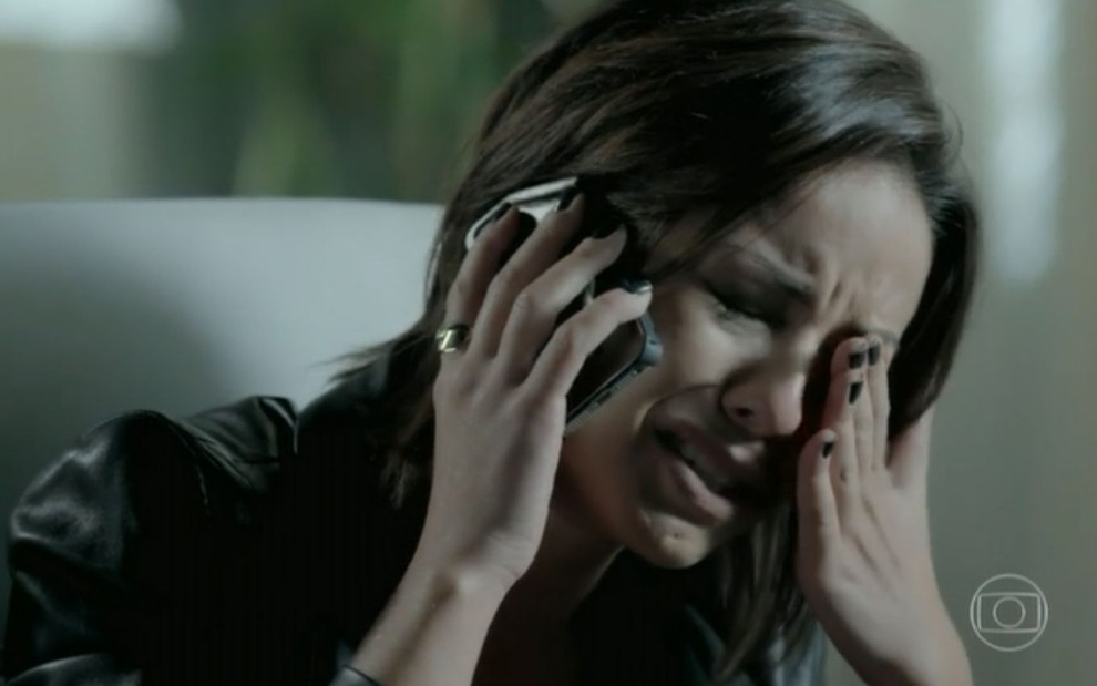 Maria Clara (Andréia Horta) fala ao celular e chora sozinha na sua sala na empresa em Império