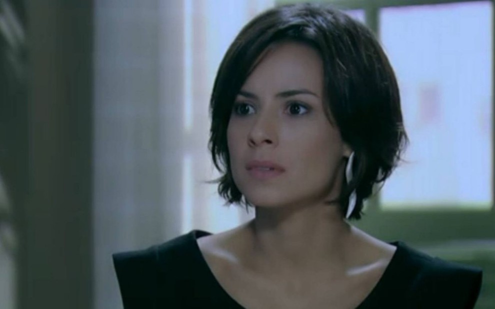 Maria Clara (Andréia Horta) está vestida de preto na sala da mansão de José Alfredo (Alexandre Nero) em cena de Império