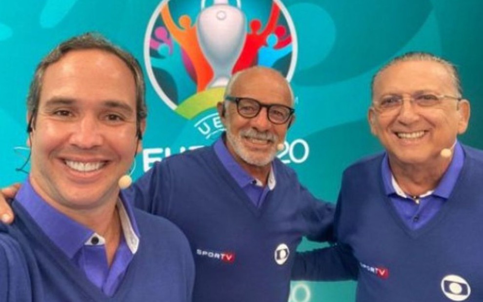 Sorridentes, Caio Ribeiro, Júnior e Galvão Bueno posam no estúdio da final da Eurocopa na Globo