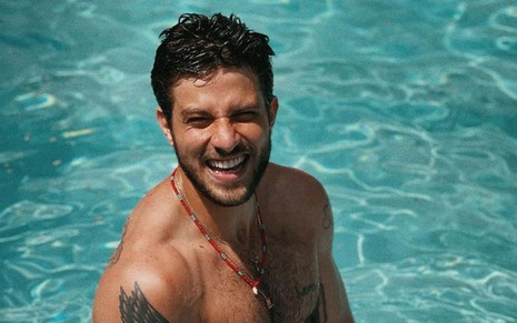 O ator Chay Suede sorri dentro de uma piscina em foto publicada no Instagram