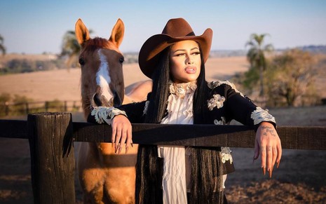 Fernanda Medrado posa com chapéu de fazendeira e ao lado de cavalo em foto promocional para A Fazenda