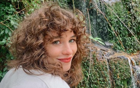 Laryssa Ayres em foto publicada no Instagram: atriz está de costas em paisagem cheia de plantas