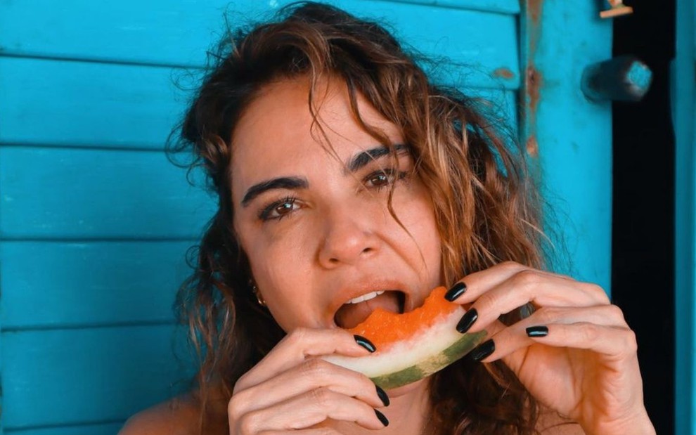 A apresentadora Luciana Gimenez come melancia em foto publicada no Instagram