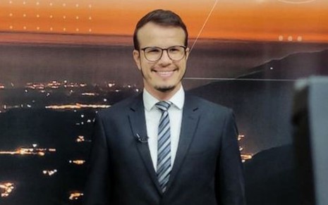 O jornalista e apresentador Rafael Silva sorri em foto tirada no estúdio da TV Alterosa, afiliada do SBT em Minas Gerais