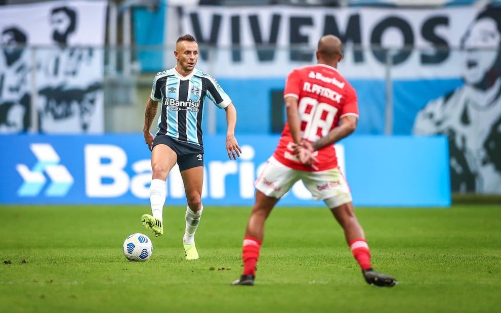 Rafinha, do Grêmio, e Patrick, do Internacional, em campo pelo Campeonato Brasileiro. Rafinha pisa na bola.