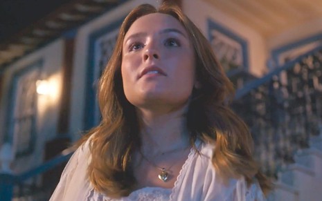 Larissa Manoela com os cabelos na altura do ombro e ruivos em cena como Isadora da novela Além da Ilusão
