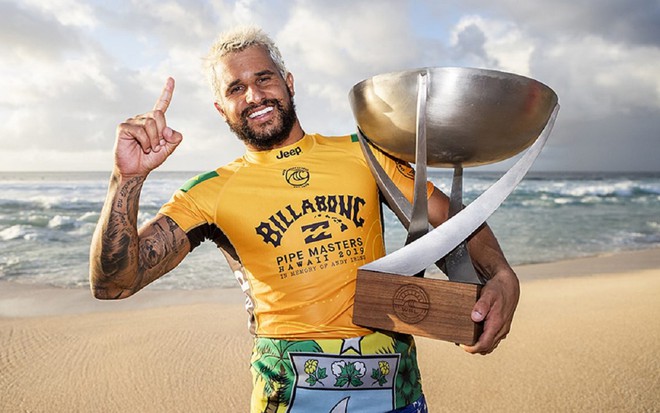 Ítalo Ferreira com uma blusa amarela e comemorando um título do Campeonato Mundial de Surfe de 2020