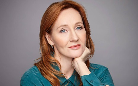 J.K. Rowling com olhar vazio e uma das mãos apoiada no rosto