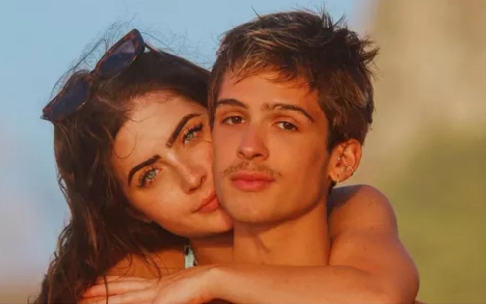 Imagem de Jade Picon (à esq.) e João Guilherme abraçados na praia
