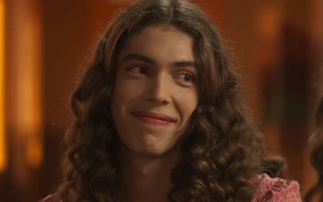 Jade Sassará com os cabelos ondulados soltos e um sorrisinho em cena da novela Mar do Sertão
