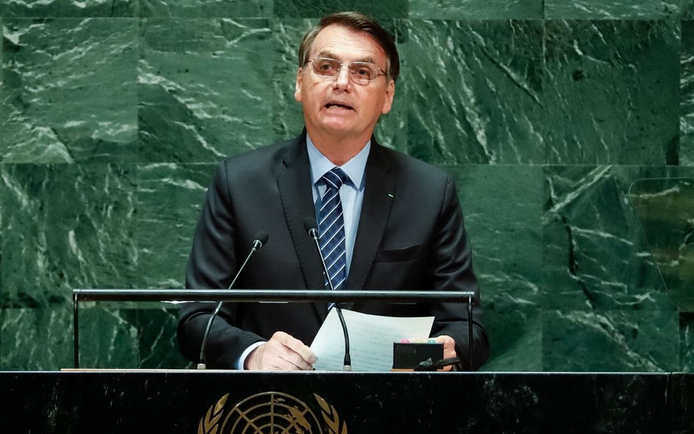 O presidente Jair Bolsonaro olha para frente e segura papel enquanto discursa na ONU (Organização das Nações Unidas)