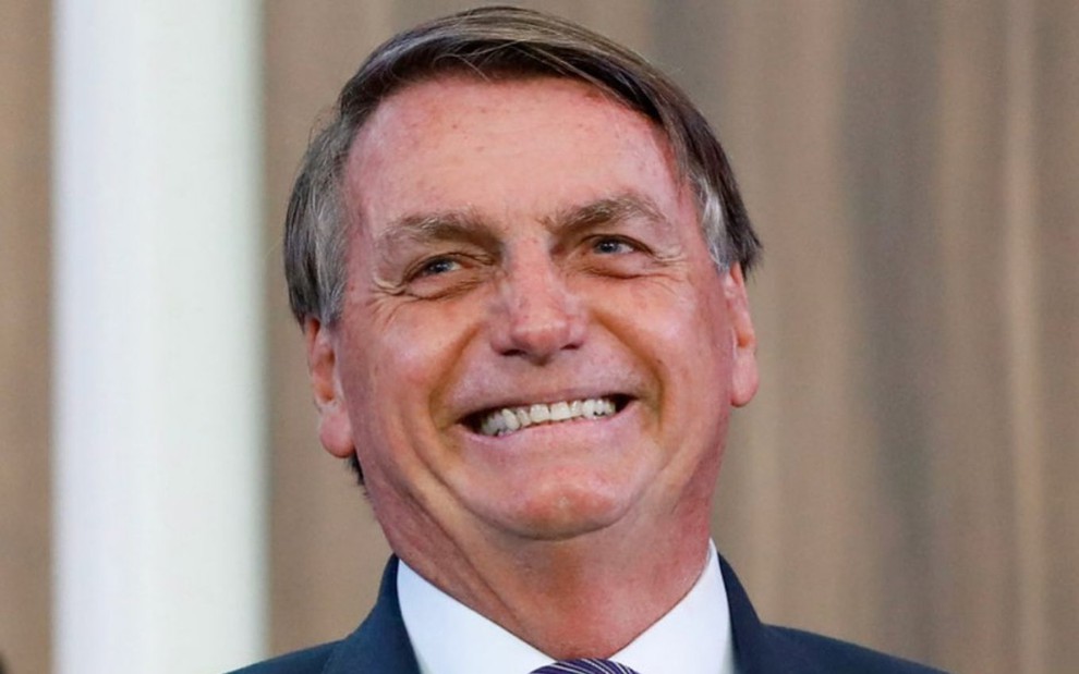Jair Bolsonaro sorri em evento