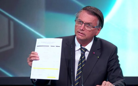 O presidente Jair Bolsonaro segura uma folha de papel no debate do SBT