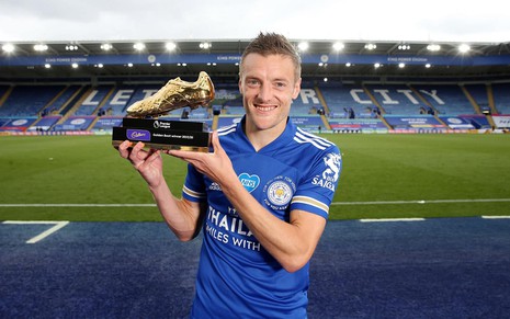 Jamie Vardy segura o troféu de artilheiro da Premier League. Ele usa a camisa azul do Leicester