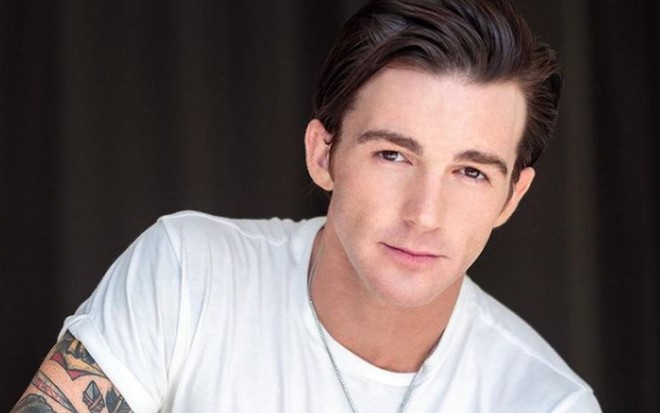 Jared Drake Bell de camiseta branca, corrente de cordão preto e cabelo penteado para trás com gel
