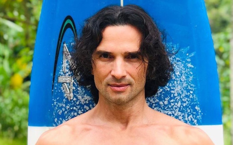 Jeff Machado posando em frente a uma prancha de surf
