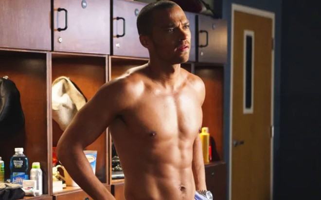 Jesse Williams em Grey's Anatomy; ele está em um vestiário e sem camisa