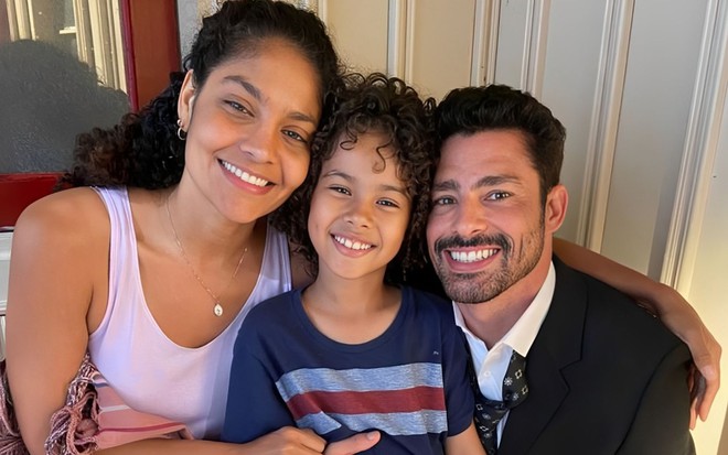 Matheus Assis está entre Barbara Reis e Cauã Reymond nos bastidores de Terra e Paixão; todos estão sorridentes