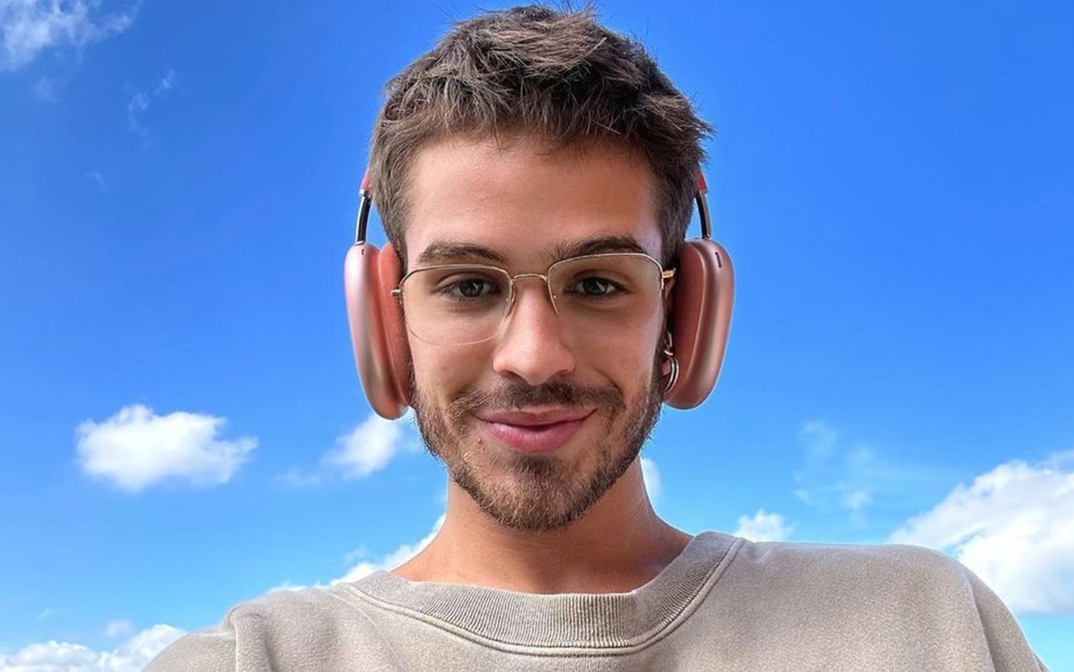 O ator João Guilherme em selfie publicada no Instagram, com fones de ouvido e céu azul ao fundo