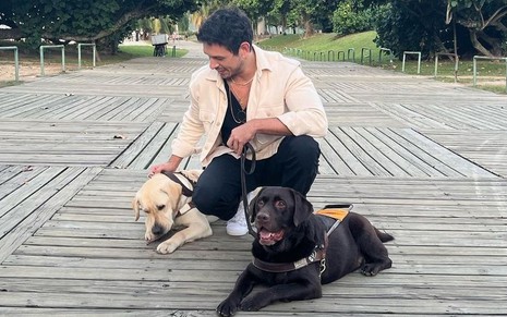 João Vicente de Castro posa ao lado de dois cachorros