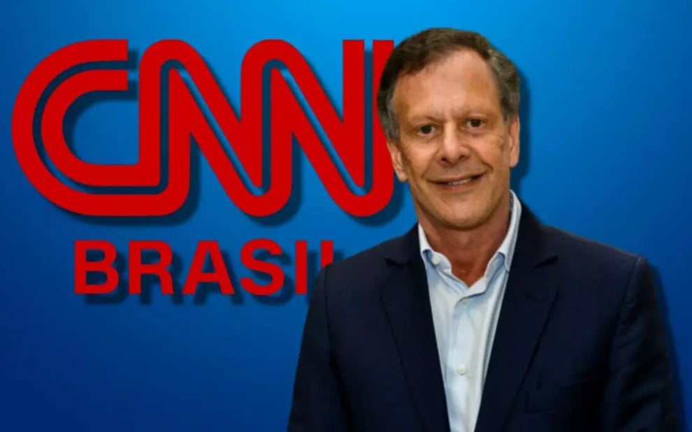 O empresário João Carlos Camargo à frente da logomarca da CNN Brasil