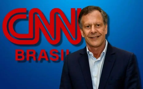 O empresário João Carlos Camargo à frente da logomarca da CNN Brasil
